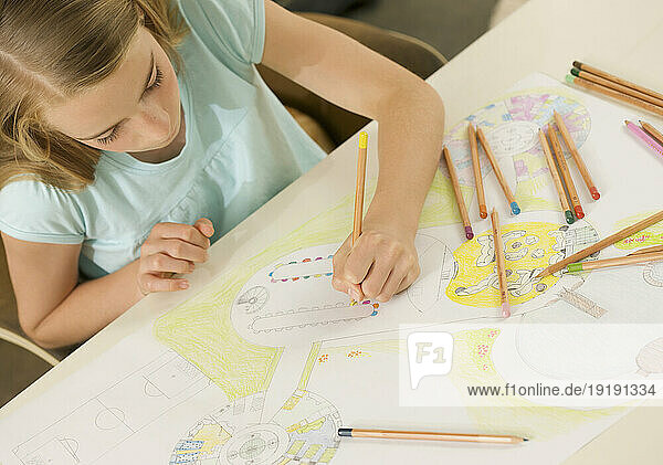 Young girl drawing with coloring pencil