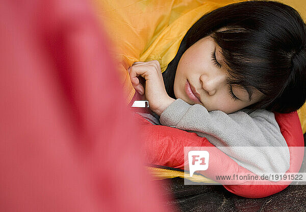 Close up of sleeping teenaged girl head coming out of tent entrance