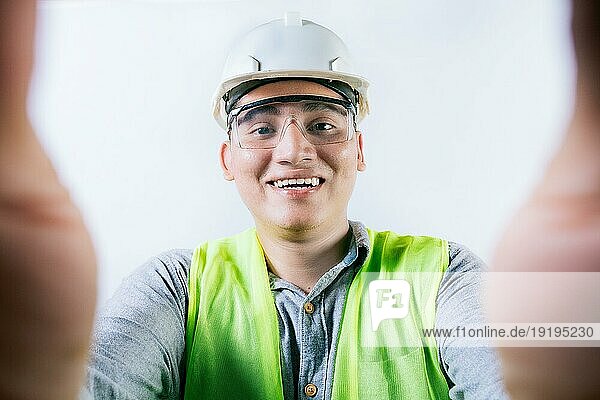 Lächelnder männlicher Ingenieur  der ein Selfie macht und in die Kamera schaut. Fröhlich Bauherr Ingenieur  der ein Selfie isoliert  Ingenieur