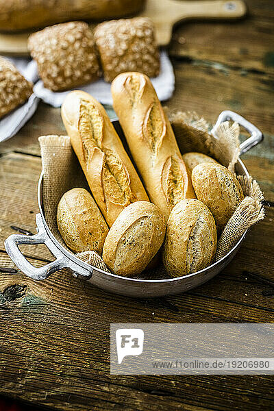 Two baguettes and four rye bread rolls in a pot