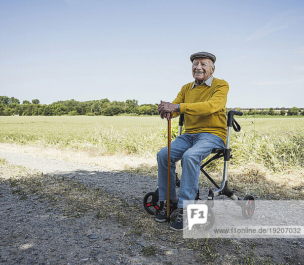 Happy senior man sitting on mobility walker