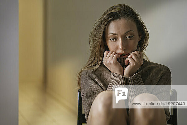 Depressed woman with brown hair at home