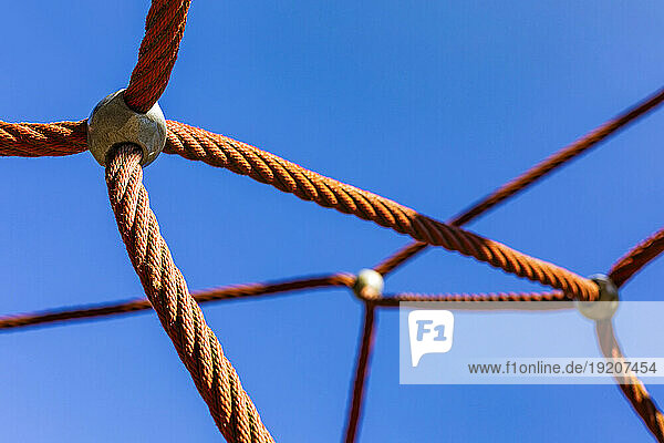 Playground ropes against clear blue sky