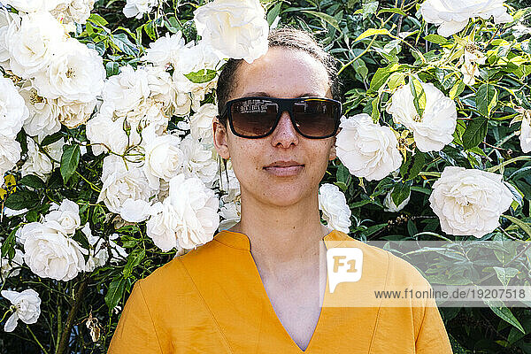 Woman wearing sunglasses amidst white flowers