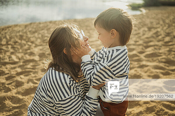 Mother and son spending leisure time at beach