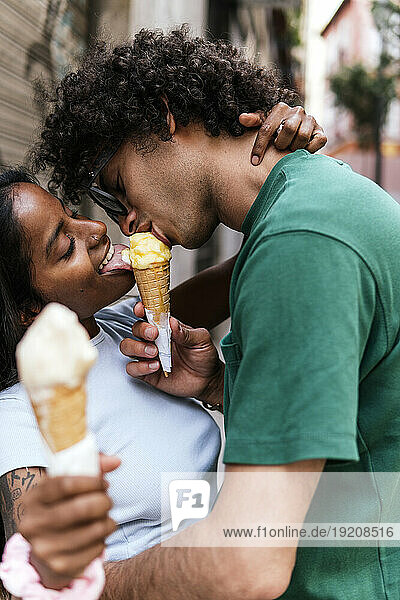 Happy couple sharing ice cream cone