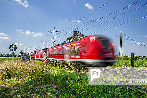 Germany  North Rhine Westphalia  Beckrath  Blurred motion of red passenger train