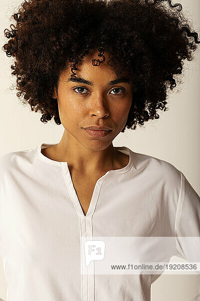 Afro haired woman standing against white background