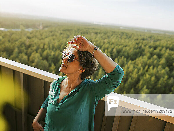 Mature woman wearing sunglasses in balcony