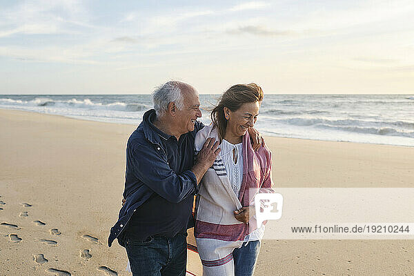 Happy senior couple together walking at beach