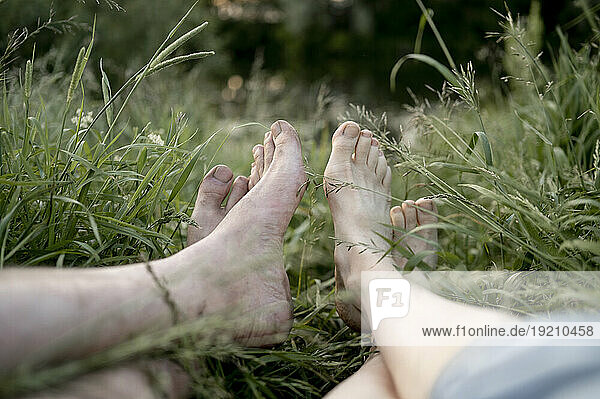 Couple relaxing together on grass in field