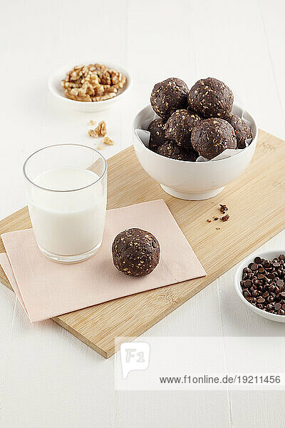 Chocolate nut balls with a glass of milk and bowl of walnuts