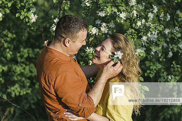 Smiling couple standing in front of blossoming tree
