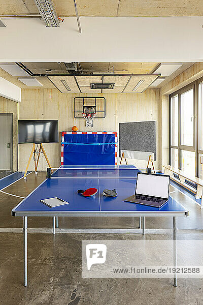 Laptop on tennis table in modern office