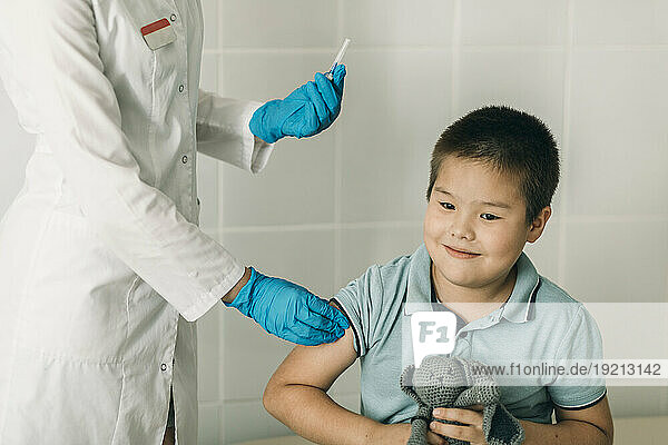 Female doctor giving vaccination to boy at medical clinic