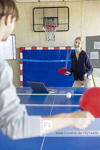 Business people playing tennis in modern office