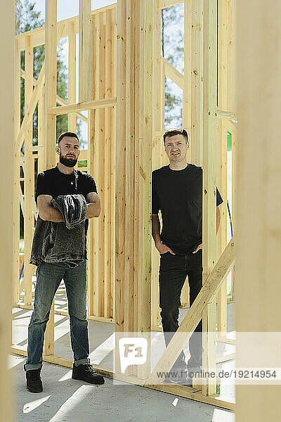 Engineers standing near wooden frame at construction site