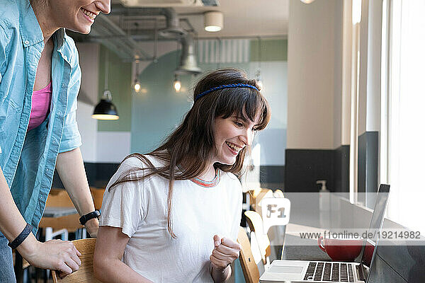 Happy freelancer with colleague working on laptop