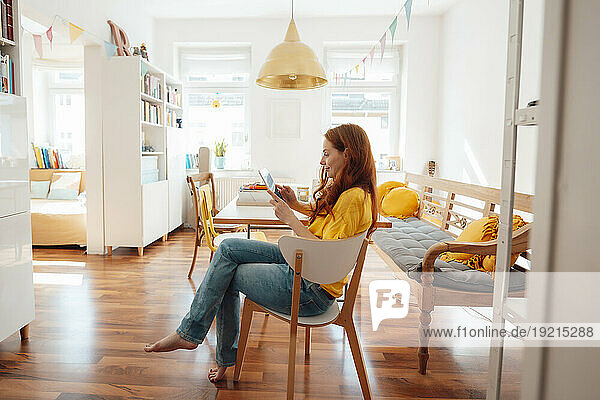 Redhead woman using tablet PC at home
