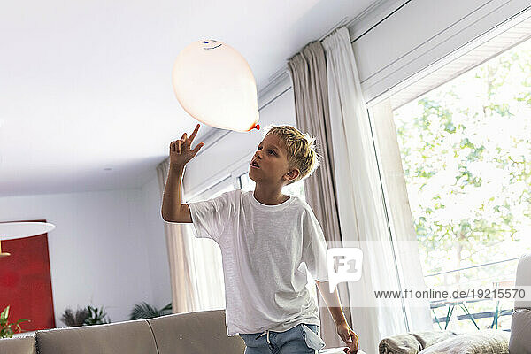 Boy playing with balloon at home