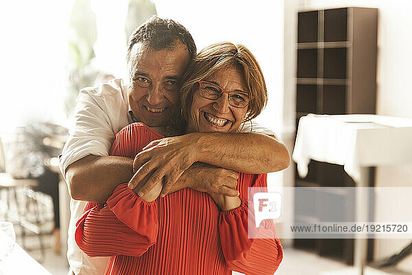 Senior couple hugging at home
