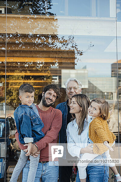 Family standing together in front of glass wall
