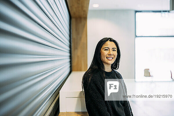 Smiling beautiful businesswoman standing at office