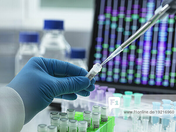 Scientist pipetting DNA sample into vial for testing