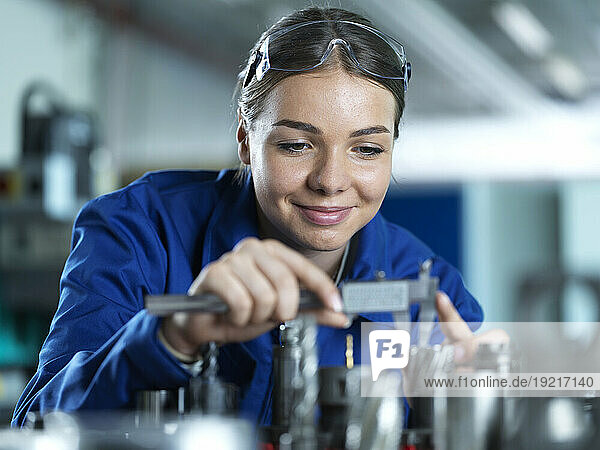 Smiling industry worker checking CNC tool in factory