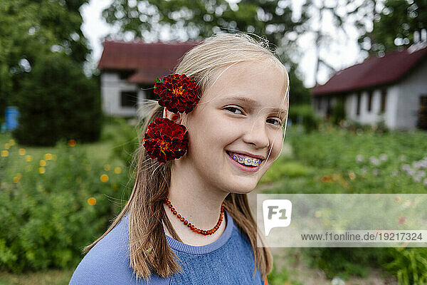 Smiling girl wearing flowers on head in garden