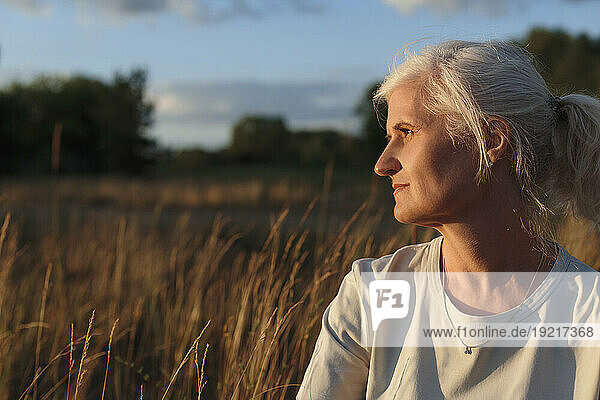 Mature woman with grey hair at sunset