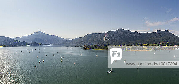 Austria  Upper Austria  Drone panorama of boats in Mondsee lake with mountains in background