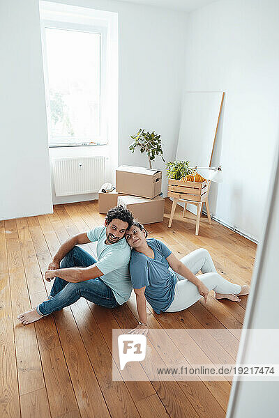 Loving couple sitting on floor at home