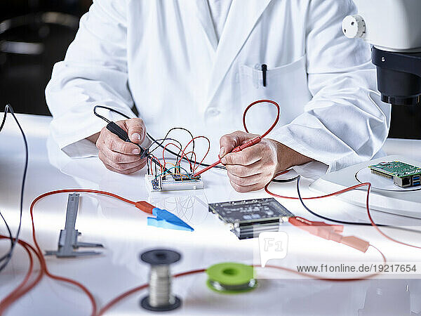 Hands of scientist working on circuit board