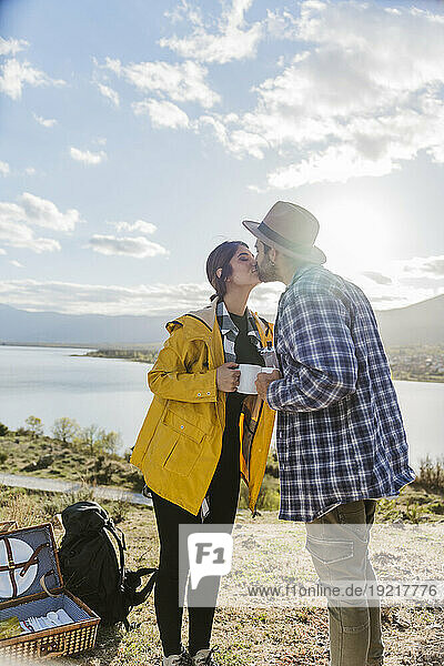 Romantic couple kissing in front of lake