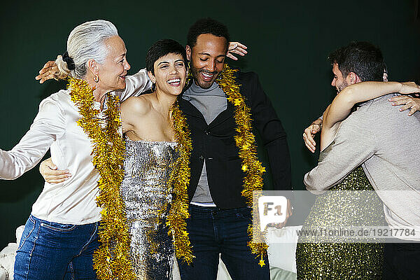 Happy family with tinsels embracing each other at new year party