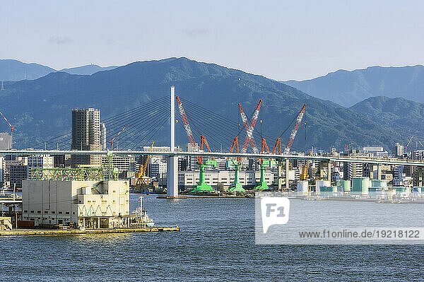 Japan  Fukuoka Prefecture  Fukuoka City  City harbor area with bridge in foreground and mountains in background