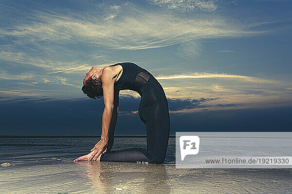 Sporty Woman Doing Yoga By The Sea