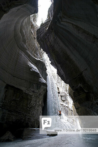 Female Climber Explores Ice Climbing In The Narrows Of Maligne Canyon In Jasper National Park  Alberta  Canada