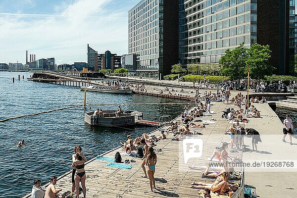 Kopenhagen  Dänemark  30. Juni 2022: Menschen genießen die Sonne an der Kalvebod Welle  einer Holzpromenade am Hafenufer  Europa