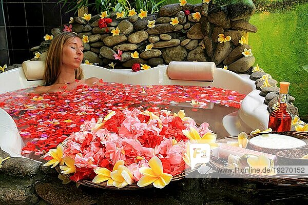 Frau beim Blütenbad  Badewanne mit Blüten geschmückt