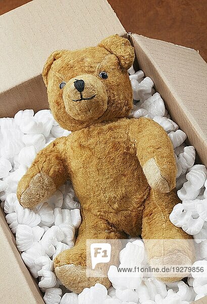 Klassischer Teddybär in einer Pappschachtel