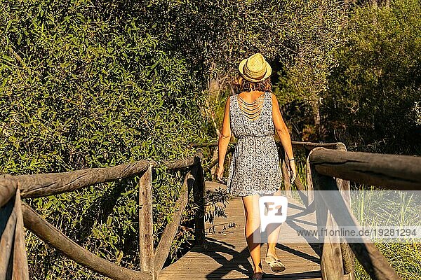 Ein junger Tourist geht auf einem Holzsteg im Doñana Naturpark in Huelva spazieren. Andalusien