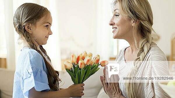 Tochter schenkt Mutter einen Strauß Tulpen