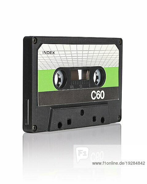 Alte kompakte Audiokassette auf reflektierendem weißen Hintergrund. Sehr geringe Tiefenschärfe