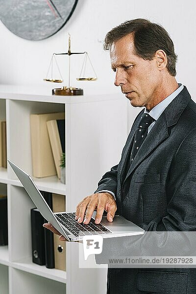 Portrait reifer männlicher Anwalt mit Laptop