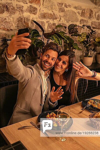 Lifestyle  ein junges  verliebtes Paar in einem Restaurant  das Spaß am gemeinsamen Essen hat  den Valentinstag feiert und ein Selfie als Andenken macht. Vertikales Foto