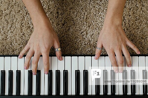 Draufsicht auf eine Musikerin  die auf einer Klaviertastatur spielt