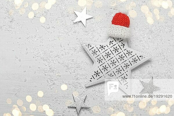 Weihnachten oder Neujahr Grußkartenvorlage mit Kopierraum  weißem Holzhintergrund mit festlicher Sterndekoration und rotem Hut