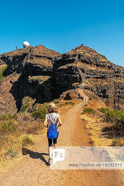 Eine junge Frau  die vom Aussichtspunkt Ninho da (Manta) in Richtung Pico do Arieiro spaziert  Madeira. Portugal